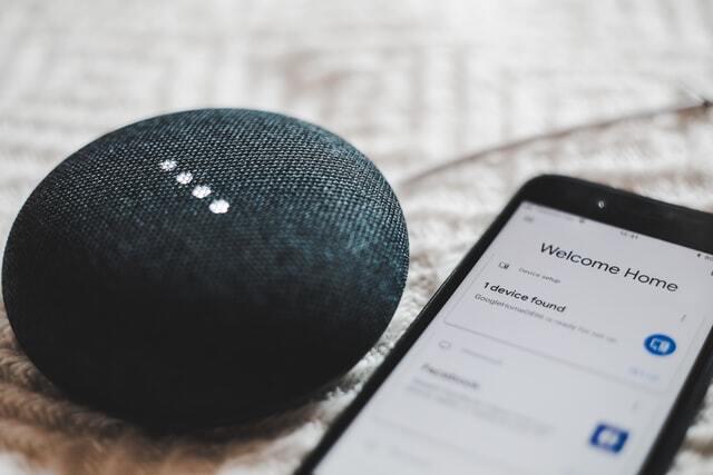 Photo of a smart speaker next to a smart phone.